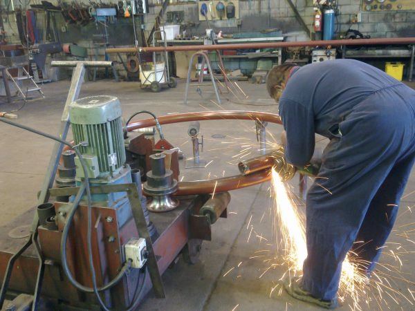 Grinding sparks flying on a pipe rolling job in the Valentine Engineering workshop