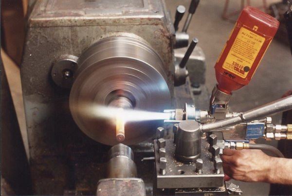 Lathe turning with cutting fluid in the Valentine Engineering machine shop